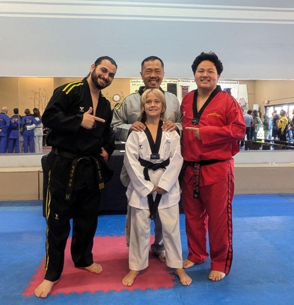 Martial arts instructors and student posing together in the Cutting Edge training studio