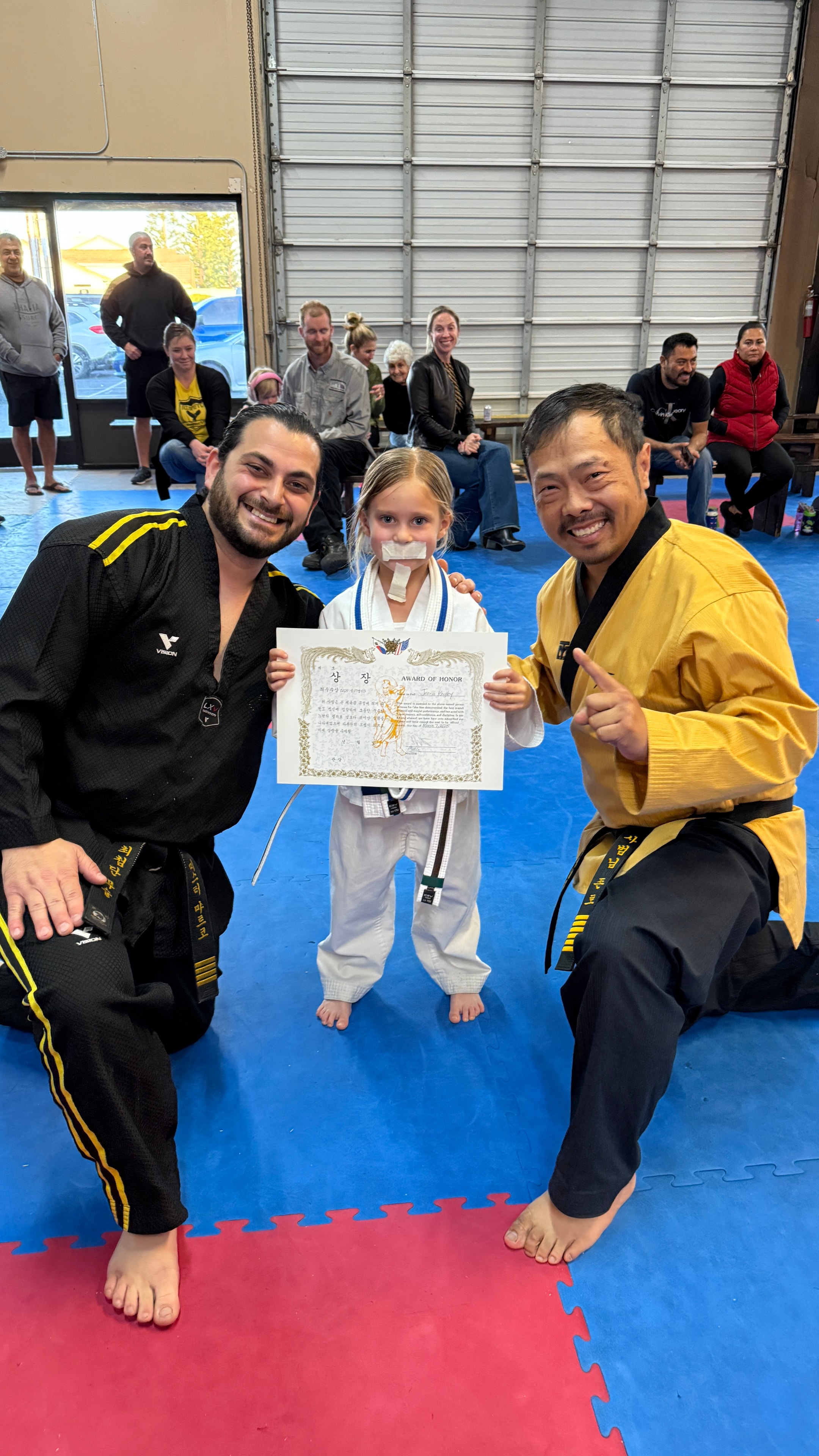 Young martial artist receiving an award with instructors