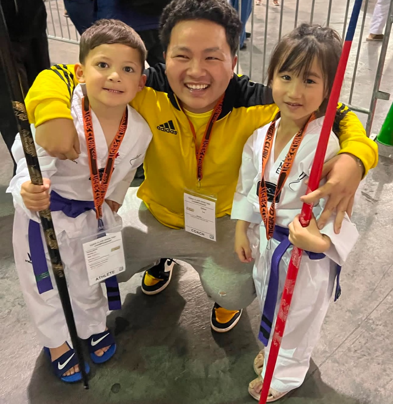 Coach posing with two young martial arts students