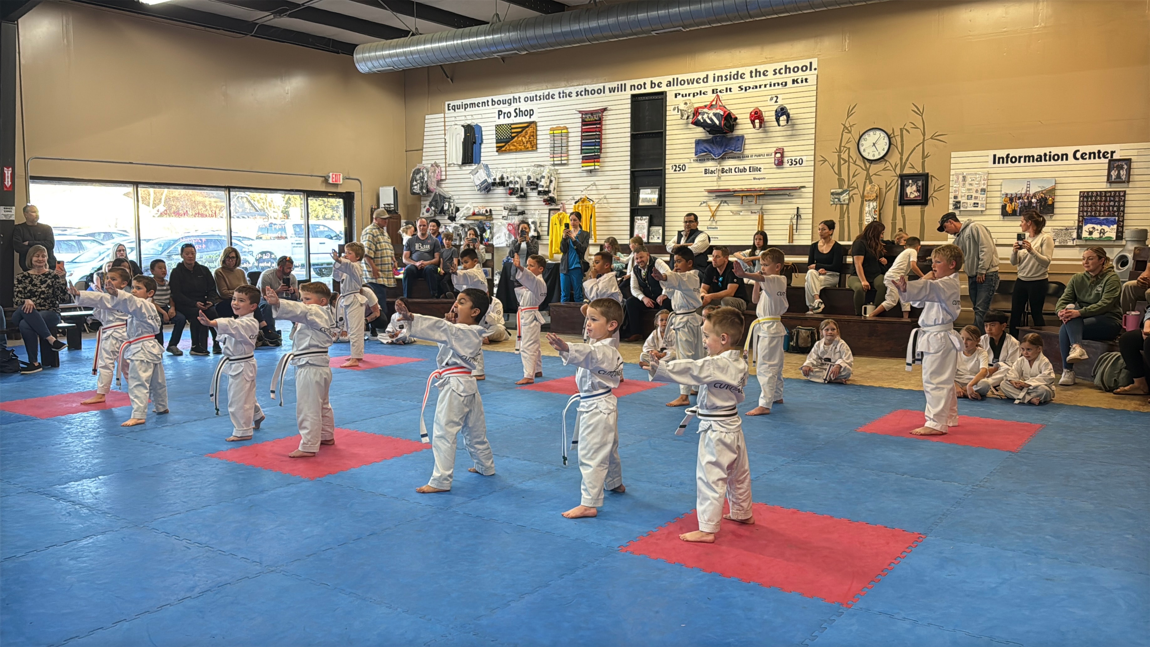 Children practicing martial arts while families watch