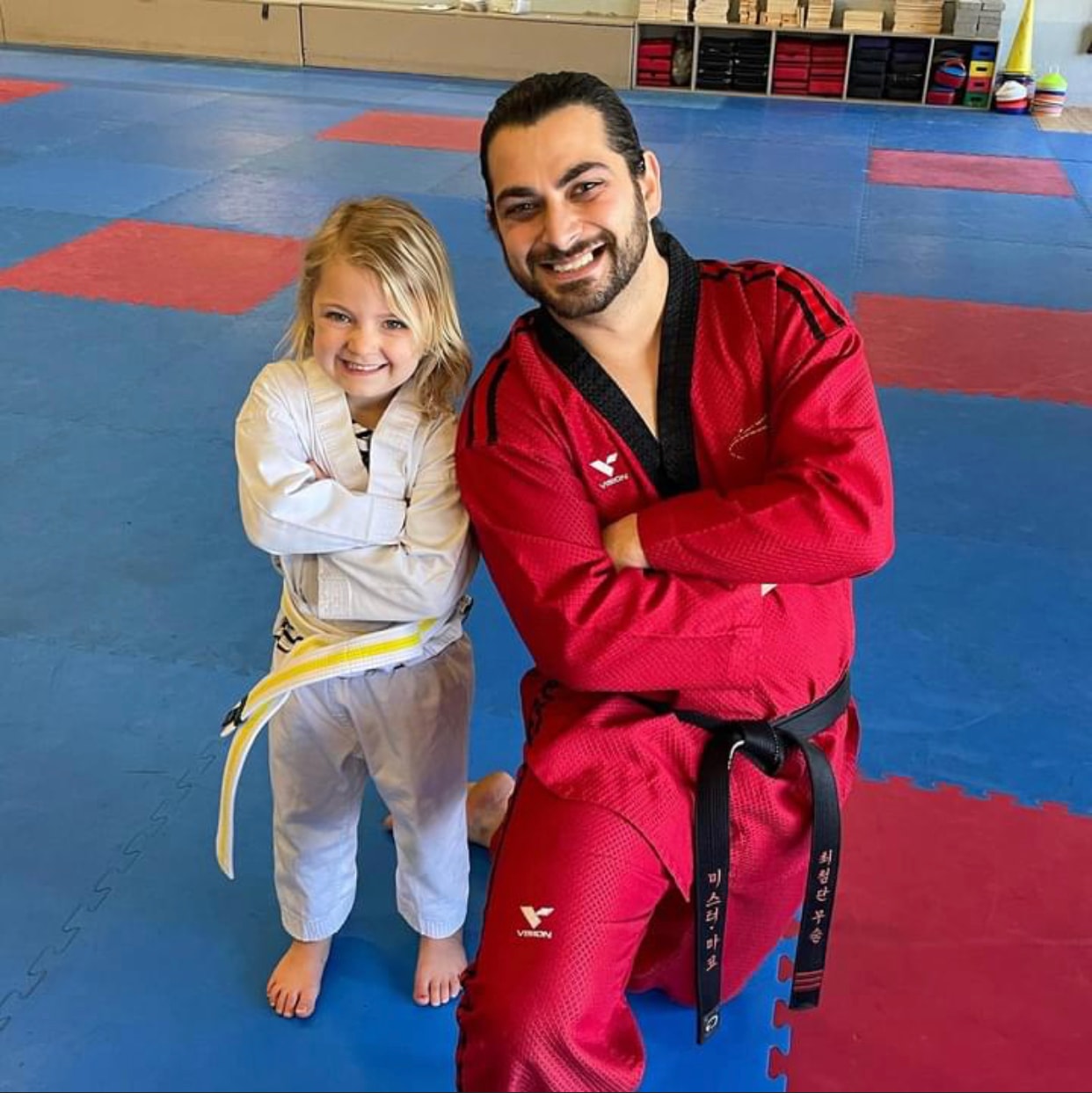 Martial arts instructor posing with a young student in the dojo