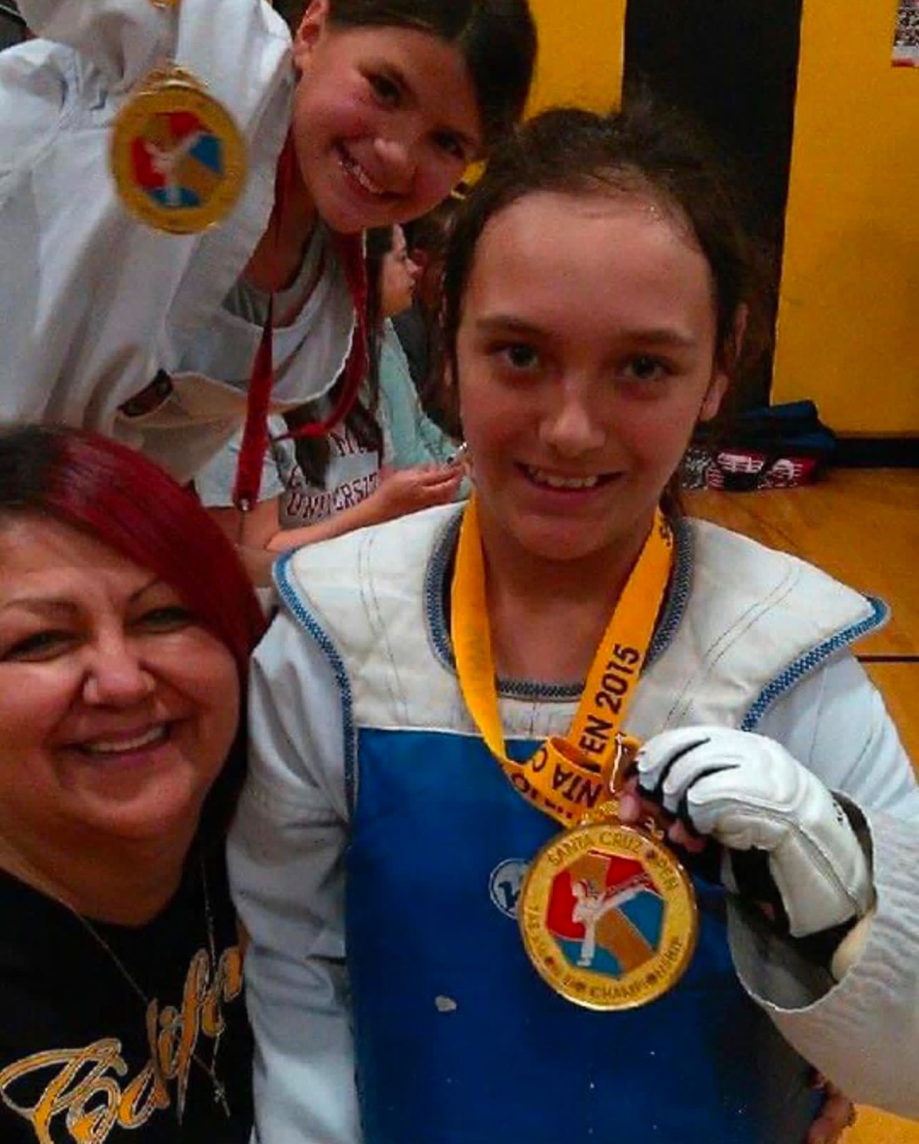 Martial arts competitors celebrating with medals
