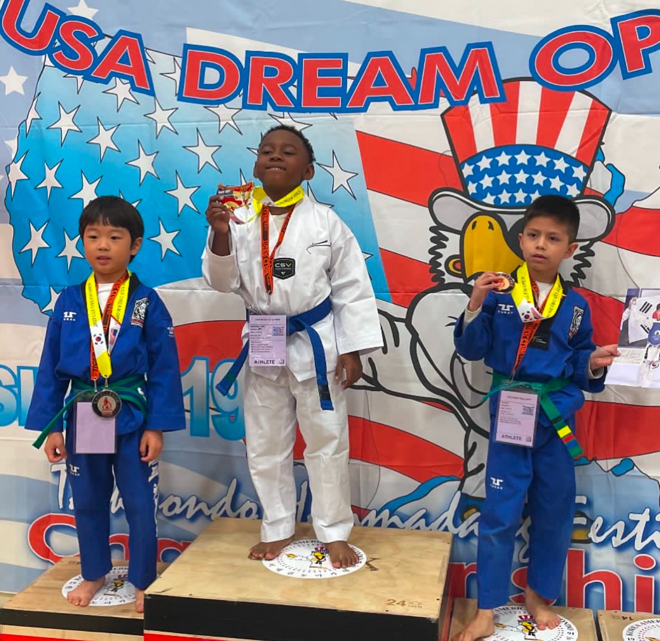 Young martial arts medalists on a competition podium