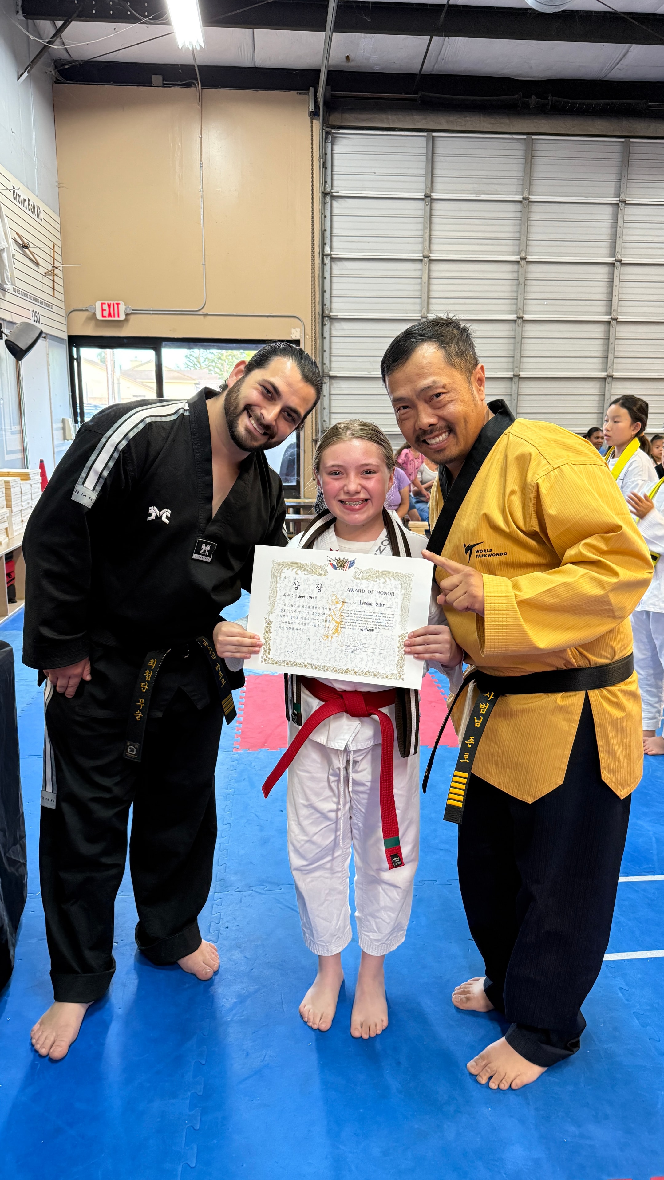 Young martial artist receiving an award with instructors
