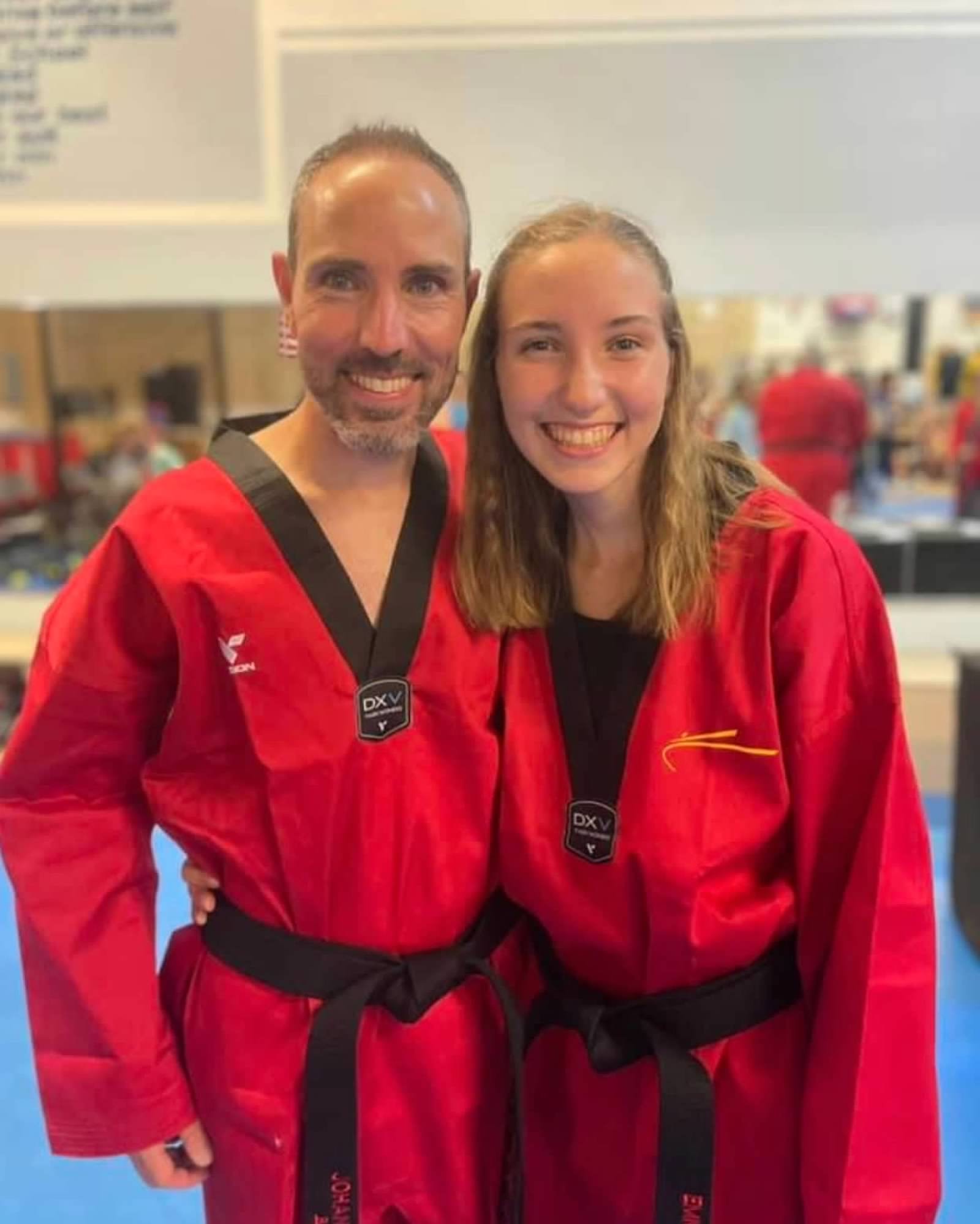 Two martial artists in red uniforms with black belts